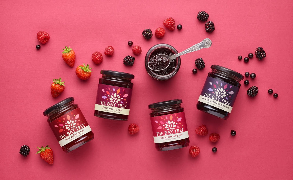 Jars of Bay Tree jam with berries on a pink background